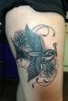 Black and grey thigh swallow and flower tattoo