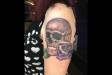 Black and grey skull and rose upper arm tattoo